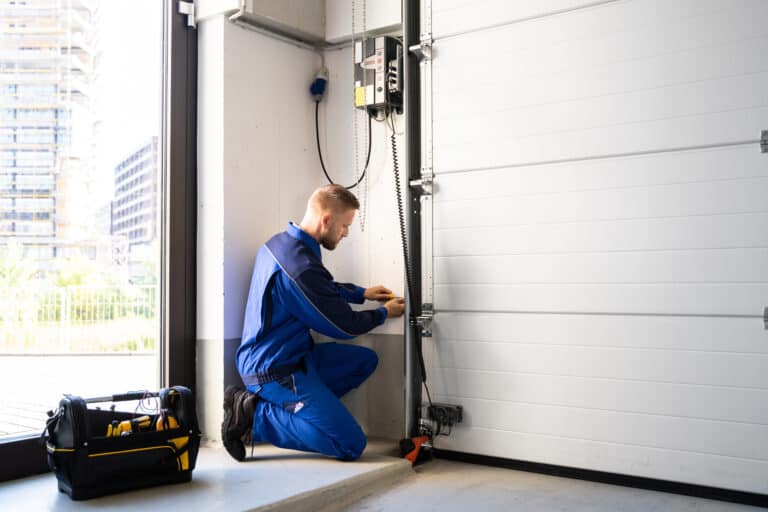 Certified technician performing seasonal garage door maintenance